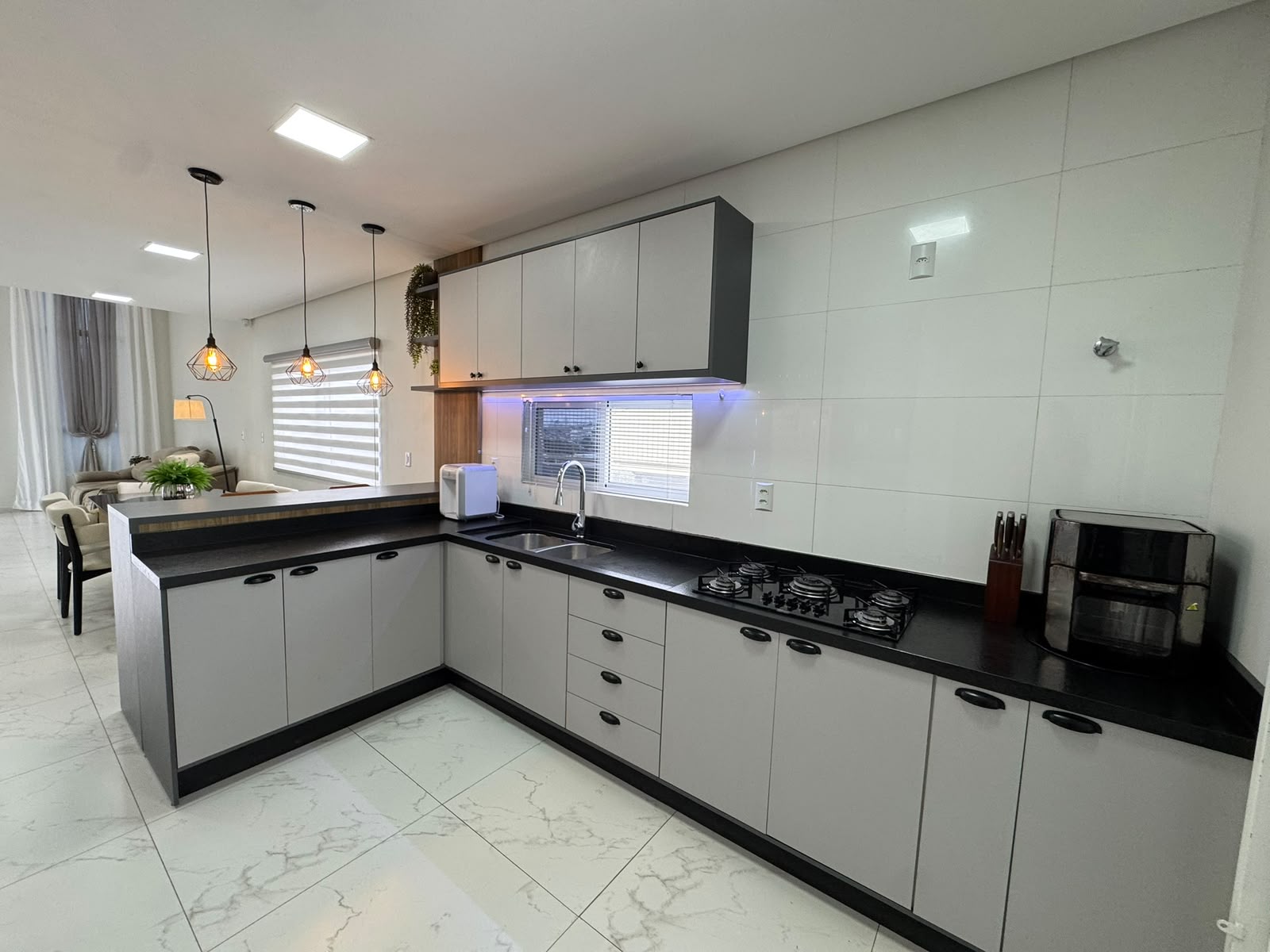 Cozinha em L com cooktop e iluminação embutida