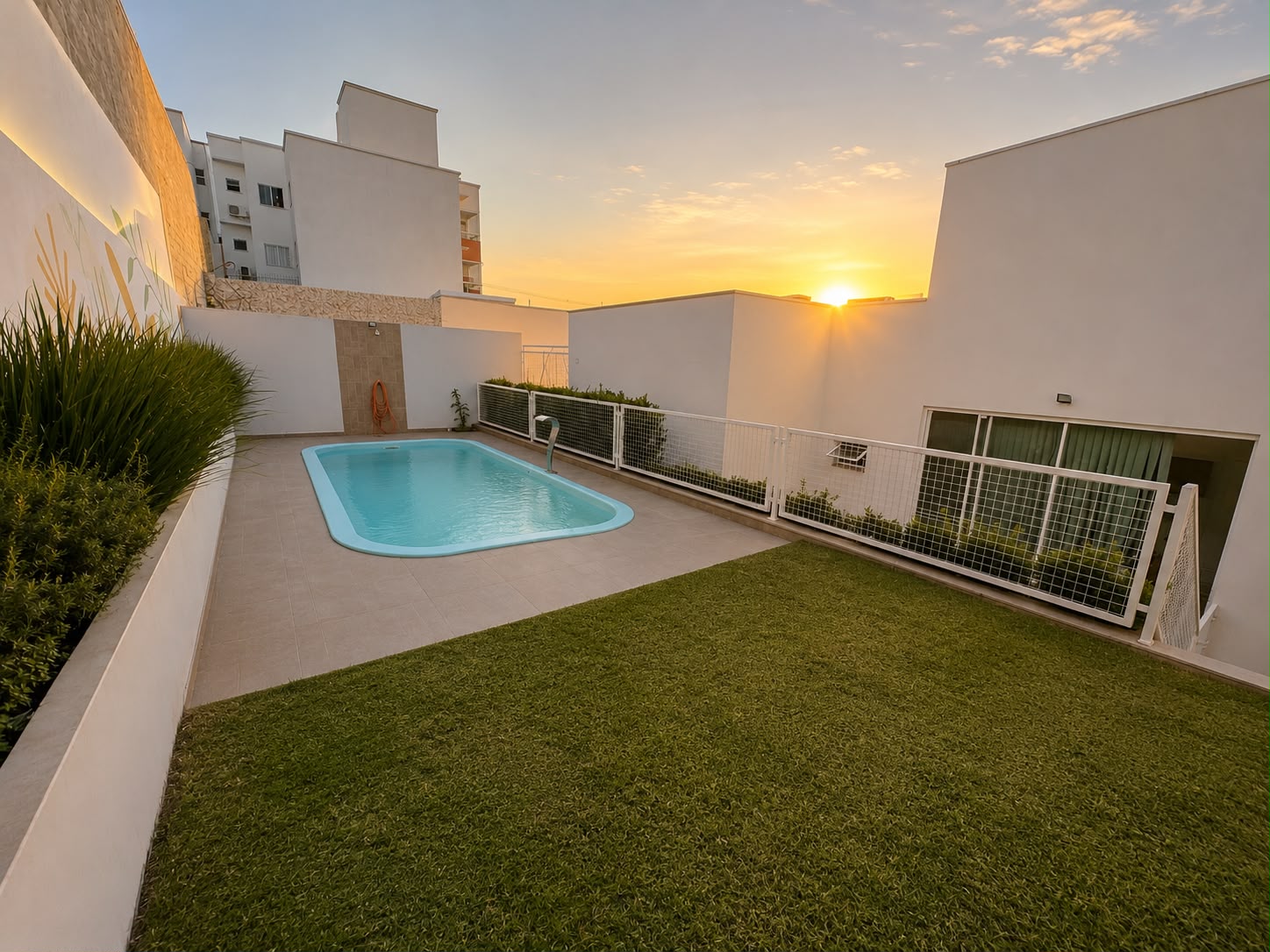 Piscina aquecida com gramado ao pôr do sol