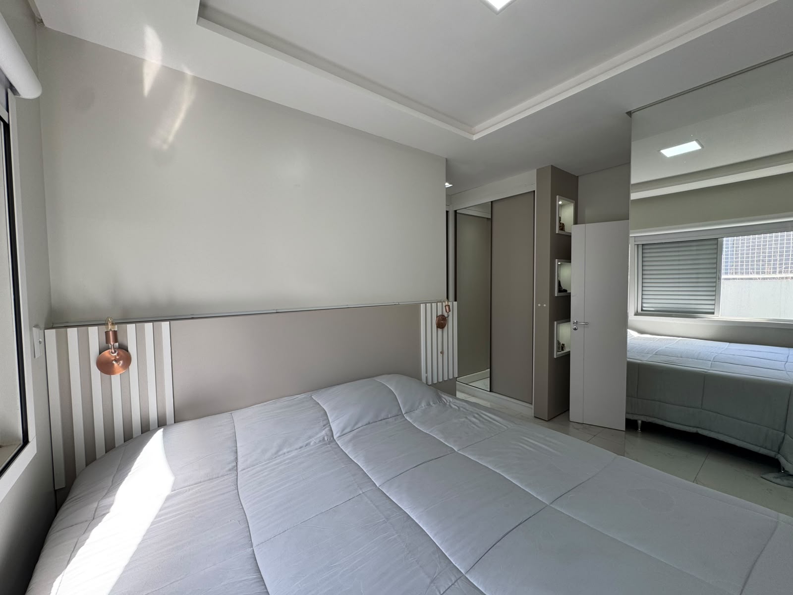 Suíte com móveis planejados e closet espelhado