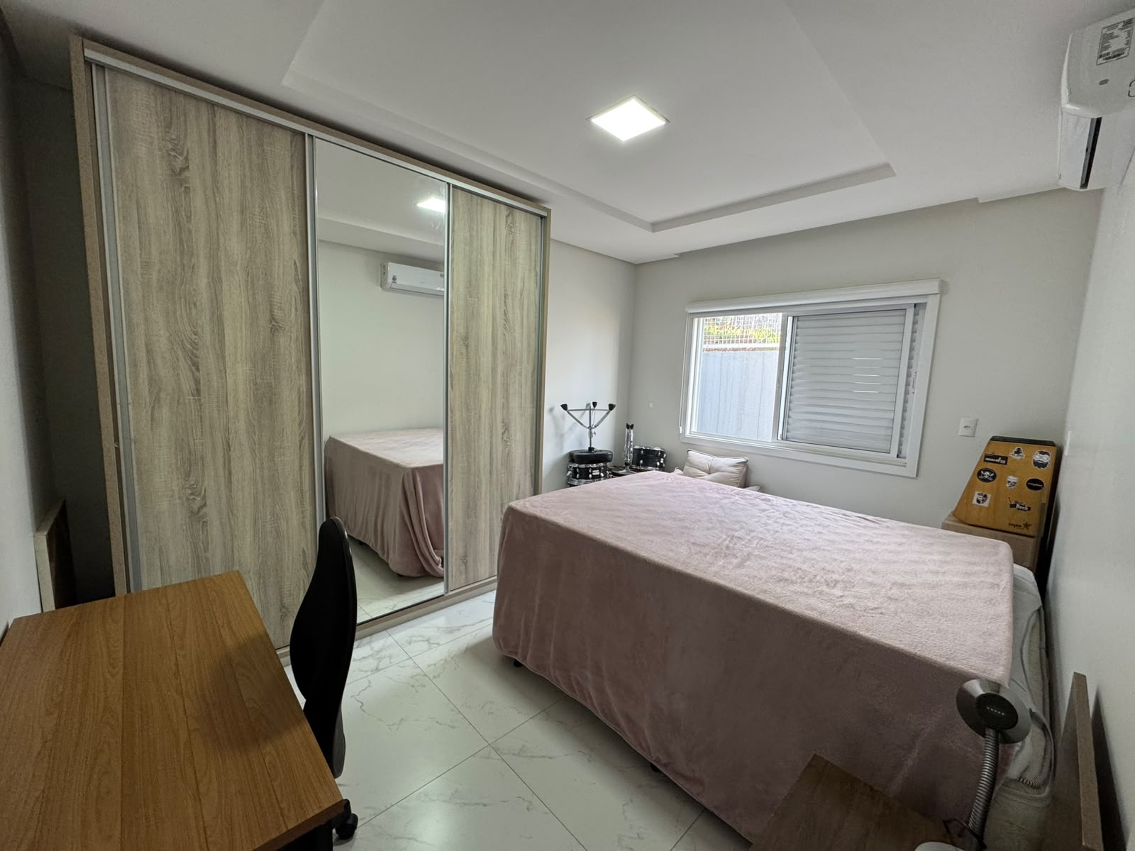 Quarto com roupeiro espelhado e escrivaninha